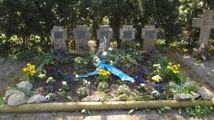 Blumenschale auf einem Grab am Waldrand
